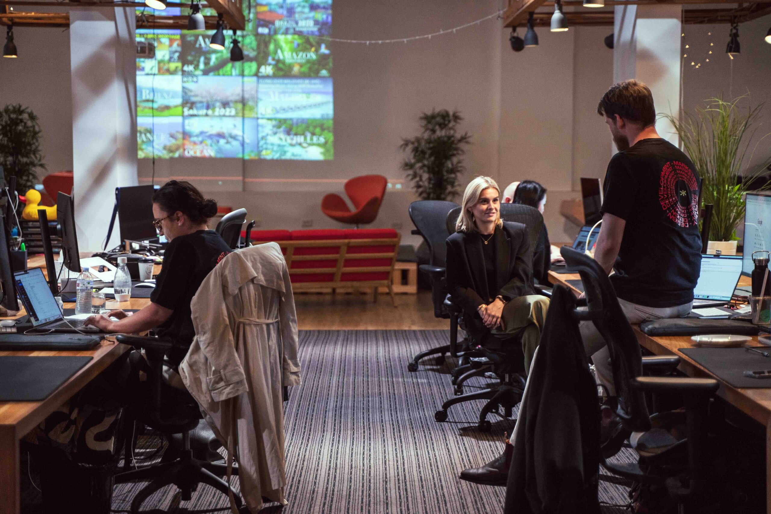 Three coworkers working at desks in office.